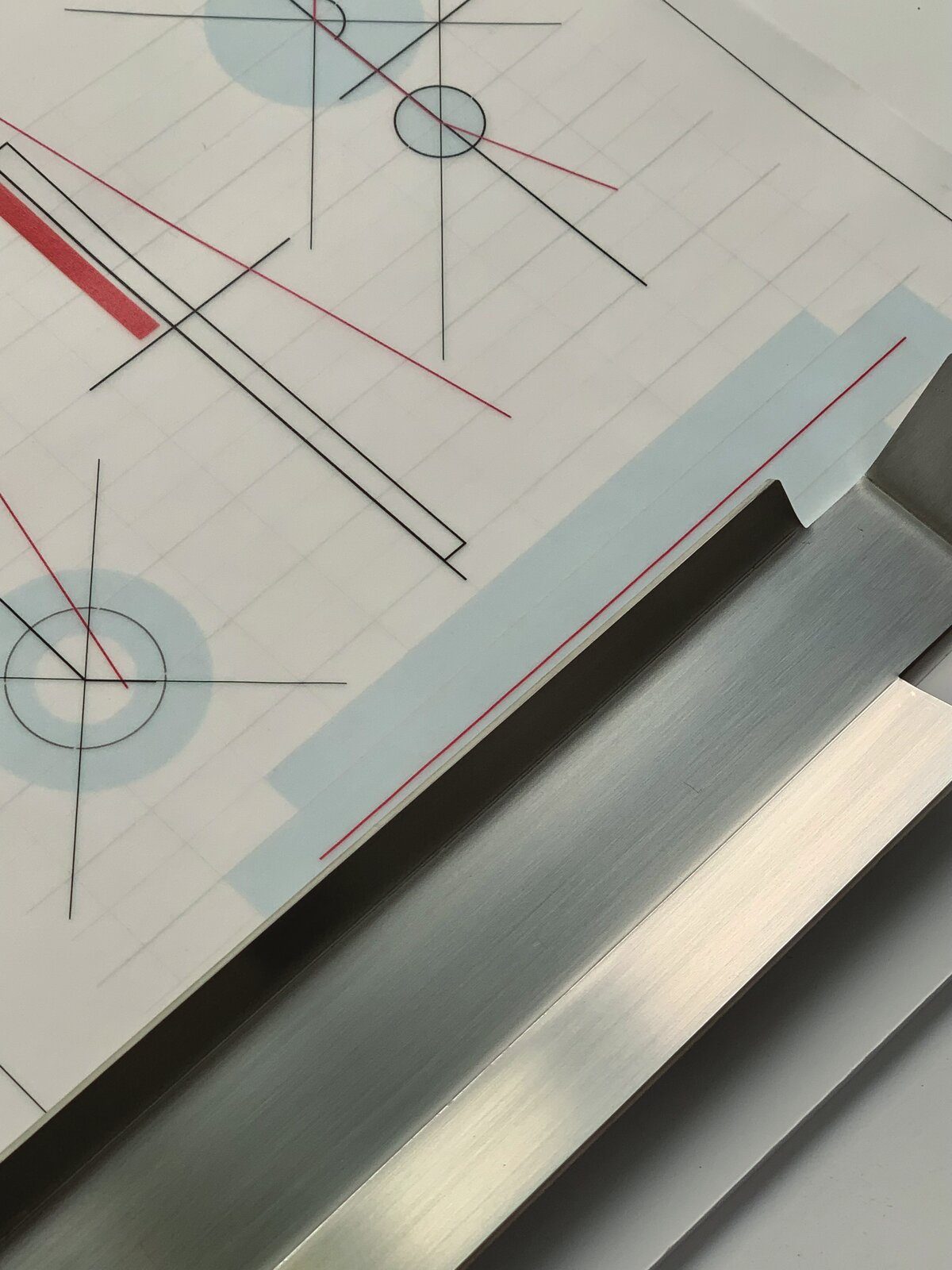 Detail: technical drawing on drafting paper resting on the bent steel sheet